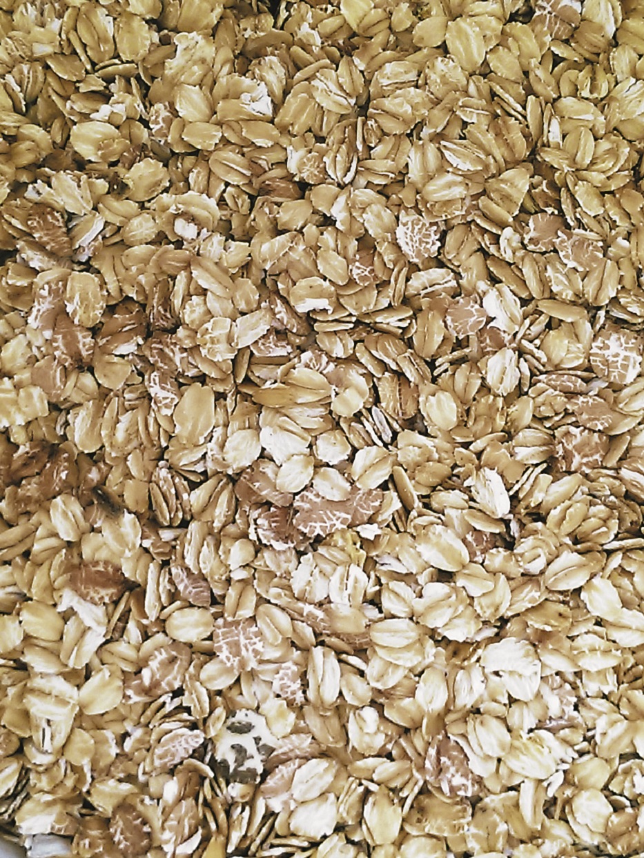 Haferflocken Eine Nahaufnahme von Haferflocken, die gleichmäßig verteilt sind.